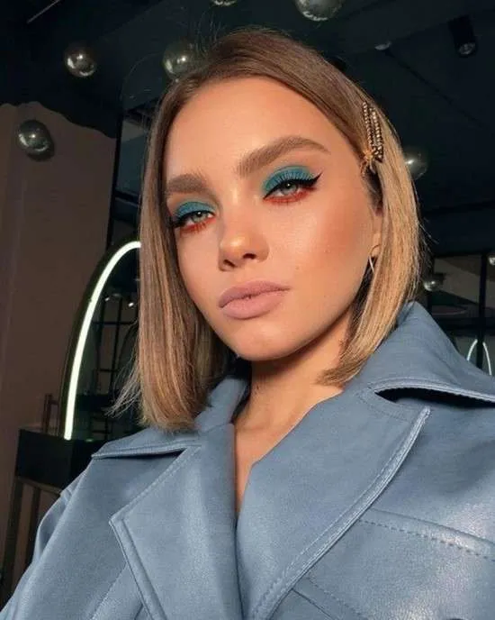 Maquiagem com sombras azul e vermelha.