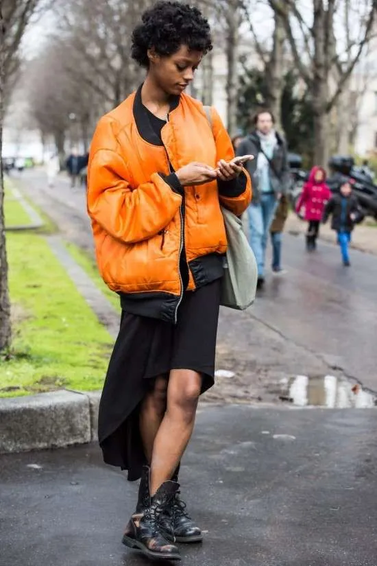 Look com jaqueta bomber e saia assimétrica.