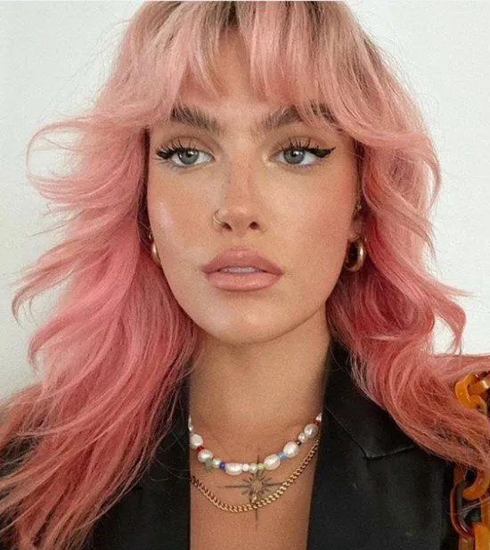 Franja cortininha ou Franja Bardot com cabelo rosa.