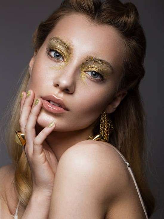 Maquiagem com glitter dourado.