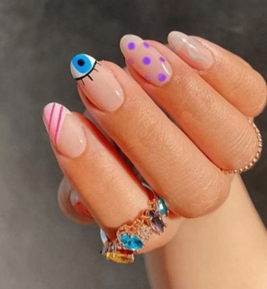 Unhas pintadas com motivos geométricos.