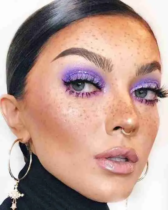 Maquiagem roxa com glitter.