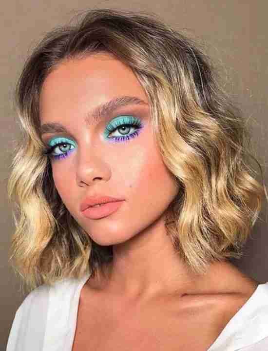 Maquiagem roxa com azul turquesa.