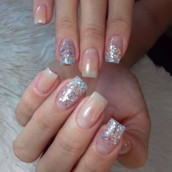 Unha clara com glitter.