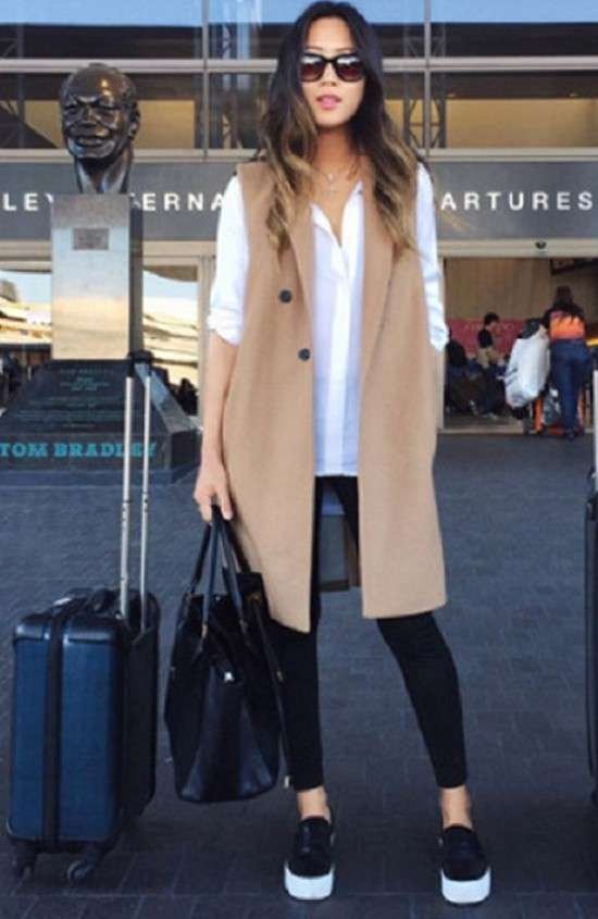 Look com colete longo, legging e tênis urbano.